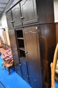 A vintage dark stained pine wardrobe unit with storage above and central shelf/cupboard unit