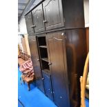 A vintage dark stained pine wardrobe unit with storage above and central shelf/cupboard unit