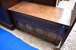 An early 20th Century oak kist with carved demi lune decoration above the four panels