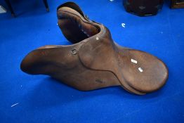 A vintage leather saddle, studs marked Gibson Saddlers, New Market