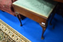 A traditional piano stool having lift top and Queen Anne style legs