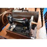 A 19th Century Singer hand crank sewing machine in oak case