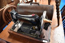 A 19th Century Singer hand crank sewing machine in oak case