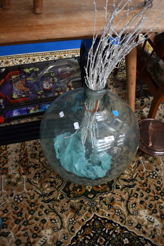 A glass carboy and decorative twigs