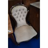 A Victorian spoon back nursing chair having later button back dralon upholstery