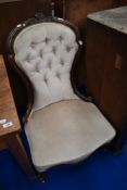 A Victorian spoon back nursing chair having later button back dralon upholstery