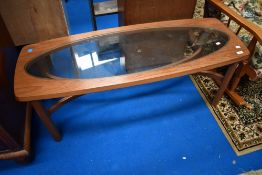 A vintage teak coffee table having oval glass inset, with stylised supports