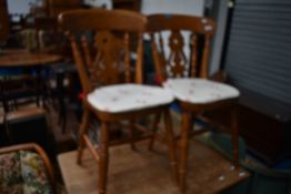 A pair of traditional stained beech kitchen chairs