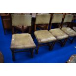 A set of four oak and leather dining chairs