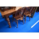 A traditional oak kitchen table and set of four wheelback kitchen dining chairs