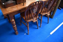 A traditional oak kitchen table and set of four wheelback kitchen dining chairs
