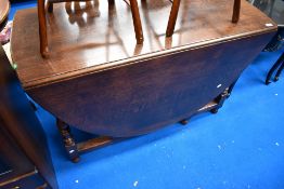 An early to mid 20th Century oak drop leaf table having turned frame