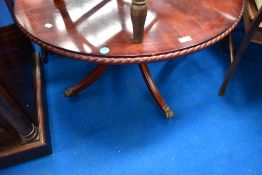 A reproduction regency style circular coffee table having gadrooned edge on quadruple splay legs