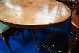 A Victorian walnut and mahogany loo table having quarter veneered oval top on carved column and