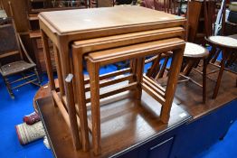 An Arts and Crafts golden oak nest of three tables, bearing marks for Stanley Webb Davies number