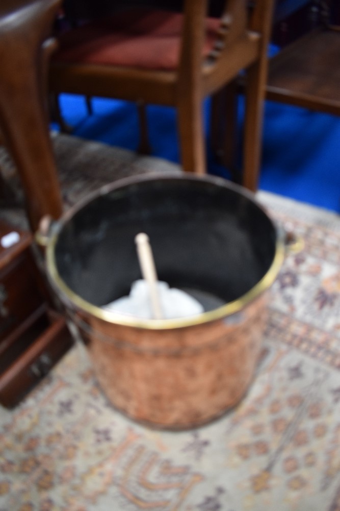 An Antique copper coal bucket with brass handle