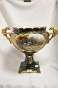 A late 19th/early 20th century two-handled urn, decorated with hunting scene vignette against a gilt