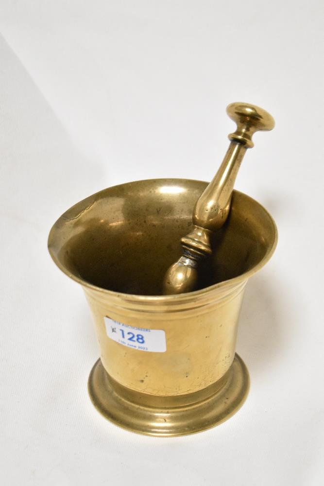 A 19th century brass mortar in typical fluted bell form with a double baluster and central knop