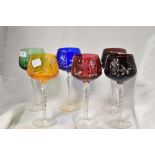 A group of six decorative coloured glasses, wheel cut/engraved with foliate and geometric designs