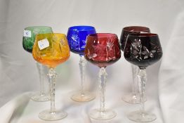 A group of six decorative coloured glasses, wheel cut/engraved with foliate and geometric designs