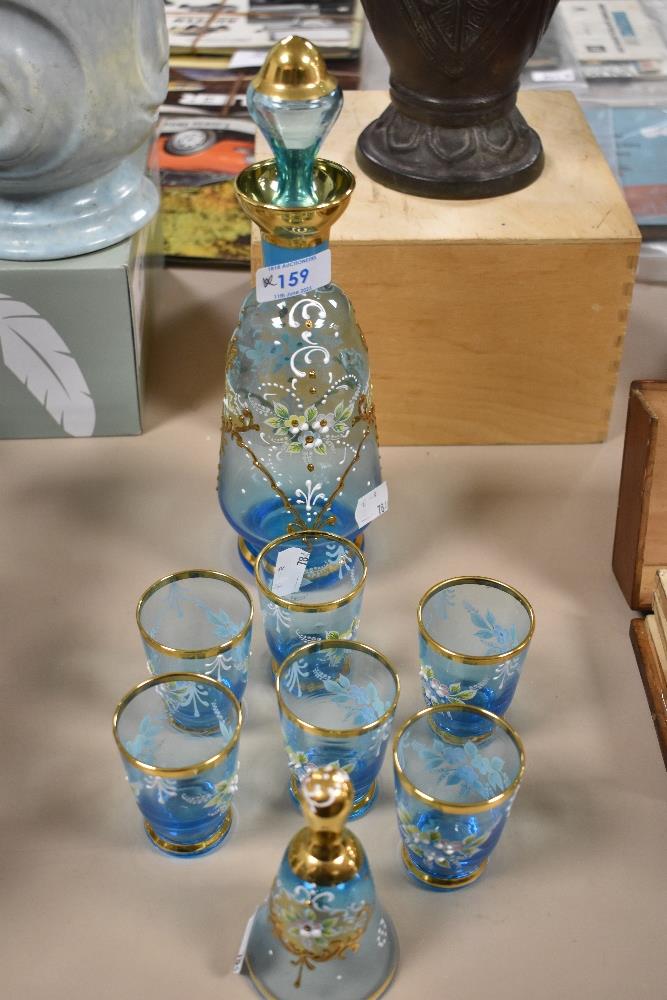 An Egyptian hand-decorated blue glass liqueur set, comprising decanter, six glasses and bell of