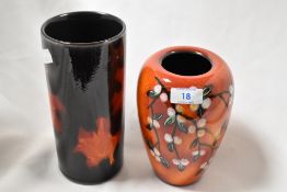 Two Poole glazed pottery vases, to include a matte black cylindrical vase with autumn leaf style