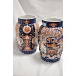 A pair of Meiji period Japanese Imari porcelain vases, of fluted form and decorated in the typical
