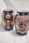 A pair of Meiji period Japanese Imari porcelain vases, of fluted form and decorated in the typical