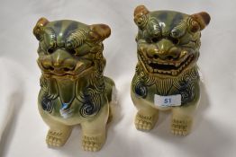 A pair of glazed pottery Foo Dog statues, measuring 18cm tall