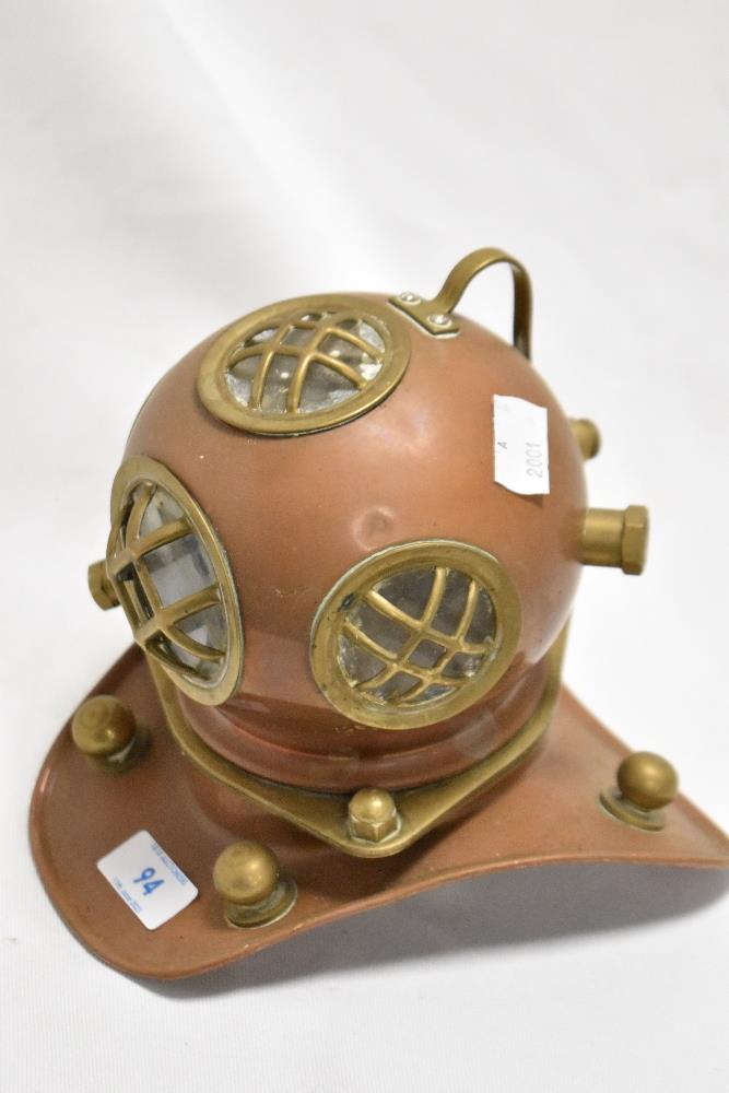 A vintage copper and brass miniature deep sea divers helmet