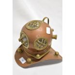 A vintage copper and brass miniature deep sea divers helmet