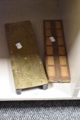 Two vintage cribbage boards, one of brass and the other of wood.