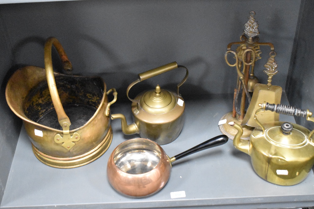 A small brass coal helmet with swing over handle, sold along with two brass kettles, copper pan