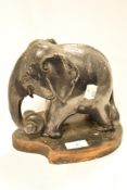 A cast lead elephant ornament displayed on a shield shaped plinth, 18cm x 20cm