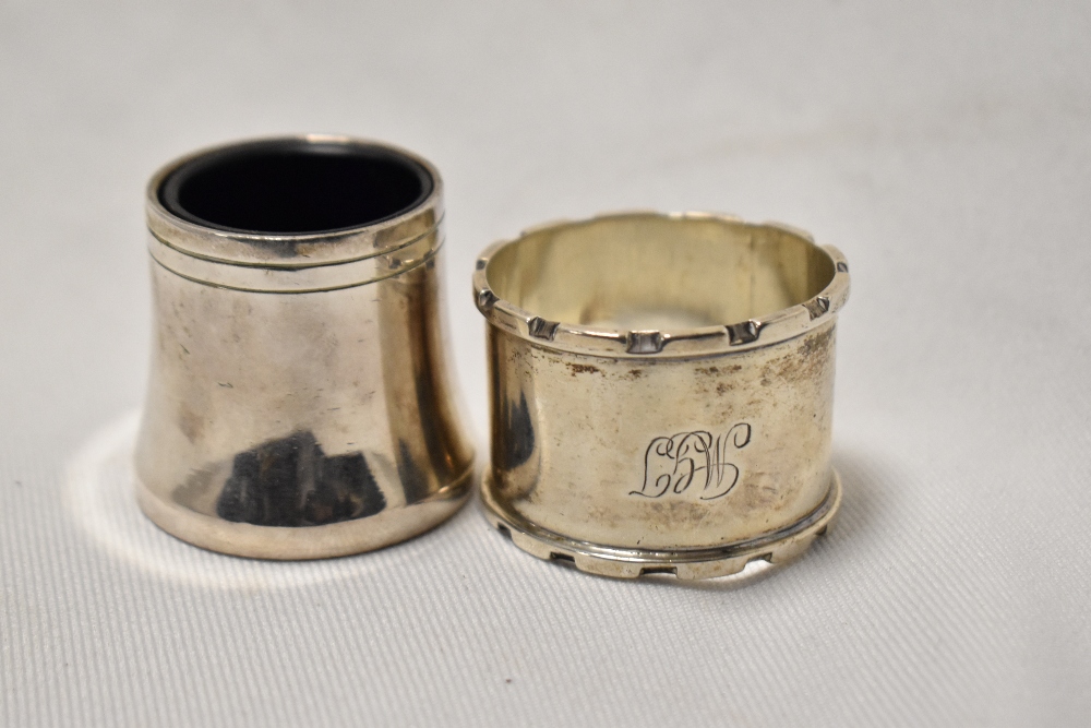 A Birmingham silver napkin ring and white metal vessel with liner