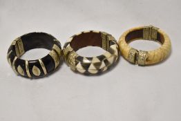 Three decorative Eastern bangles with white metal mounts