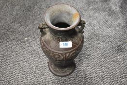 A Chinese cast-metal vase, of traditional baluster form with two bird head handles archaic