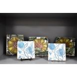 Five William De Morgan style glazed pottery tiles decorated with stylised flowers