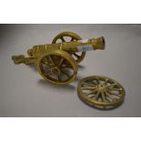 A vintage brass canon and a cartwheel.