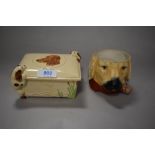 A mid century DBC ware trinket box with relief spaniels to sides and lid, and a novelty pipe smoking