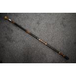 A stained bamboo walking cane, with turned wooden handle , stained decoration and drilled 'holes' gi