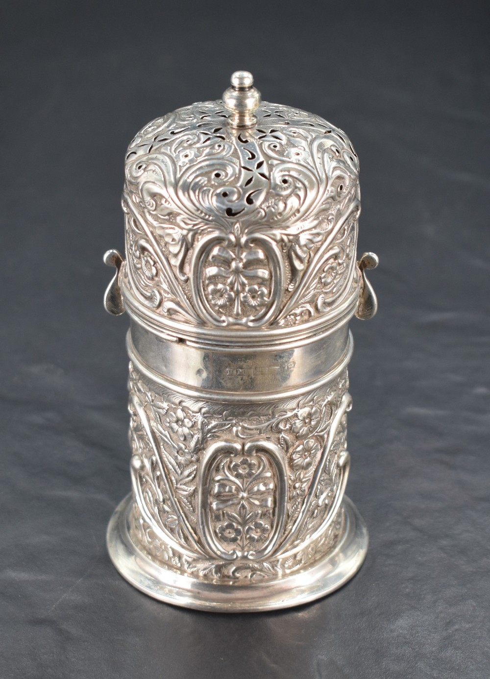 An early 20th century silver flour dredger, the domed, finial topped and pierced twist-off cover