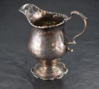 A George III silver cream jug, of baluster form with embossed rim, moulded spout and lobed