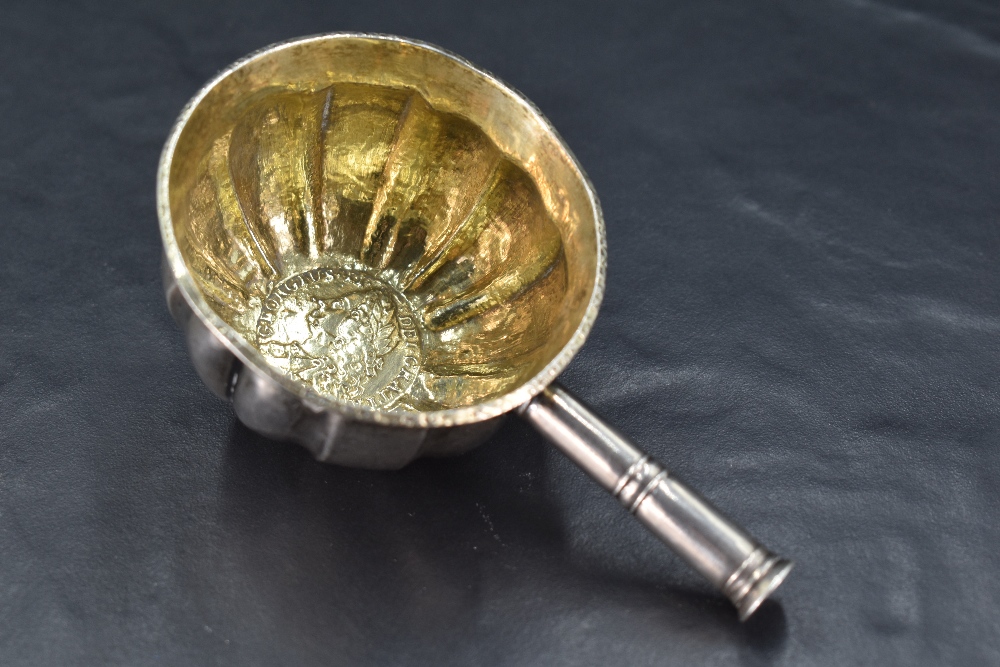 An 18th century white metal toddy ladle bowl, of fluted and dished cylindrical form with shallow