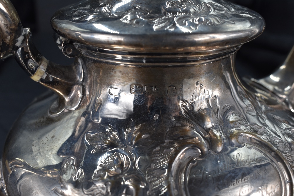 A Victorian silver teapot, having a domed foliate finial topped cover with embossed foliate - Image 2 of 3