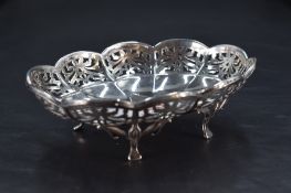 A small George V silver dish, of lobed and fluted oval form with foliate pierced border, raised on