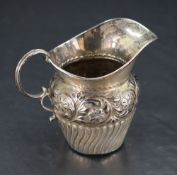 A Victorian silver cream jug, of traditional form with embossed foliate and reeded detail, marks for