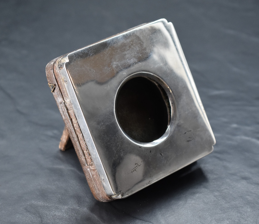 A George V silver mounted watch holder, of hinged square form with re-entrant corners, opening by