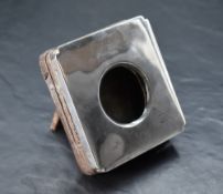 A George V silver mounted watch holder, of hinged square form with re-entrant corners, opening by