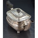 A George V silver teapot, of rounded rectangular form with hined finial topped cover within a